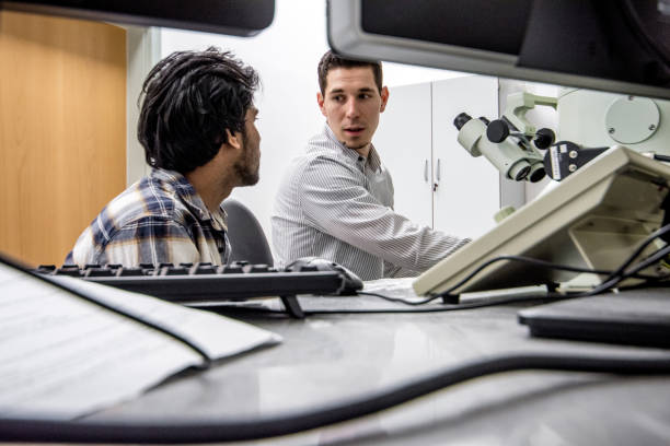 istock Two Scientists Talking About Search Results From Field Emission Electron Microscope 976578786
