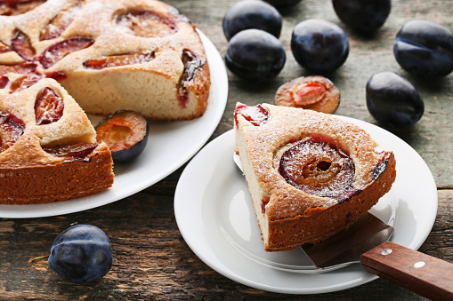 Sweet plum cake on grey wooden table
