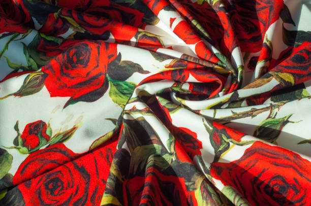 istock Texture, background, pattern. Cloth Silk Abstract Pattern. On the fabric are painted roses. Red roses on a white background 976585286