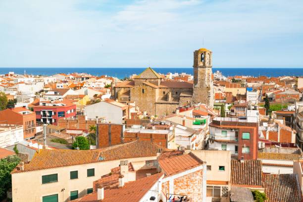 vistas desde la colina de los tejados de la antigua de ciudad de malgrat mar (españa) con el mar mediterráneo de fondo y la catedral de la costa en el centro - maresme fotografías e imágenes de stock