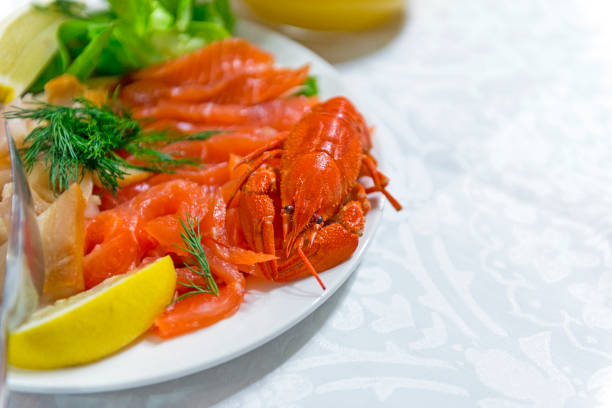 istock boiled river crayfish, crawfish, lemon slices, sliced salmon on a plate, table setting, cooked food 976589202