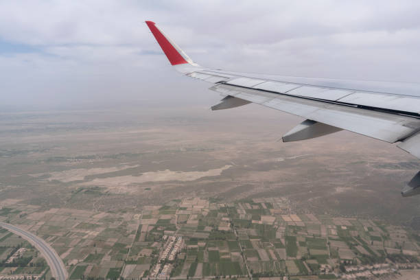 airplane wing in mid-air, flying over the city - cloud mid air cloudscape aerial view imagens e fotografias de stock