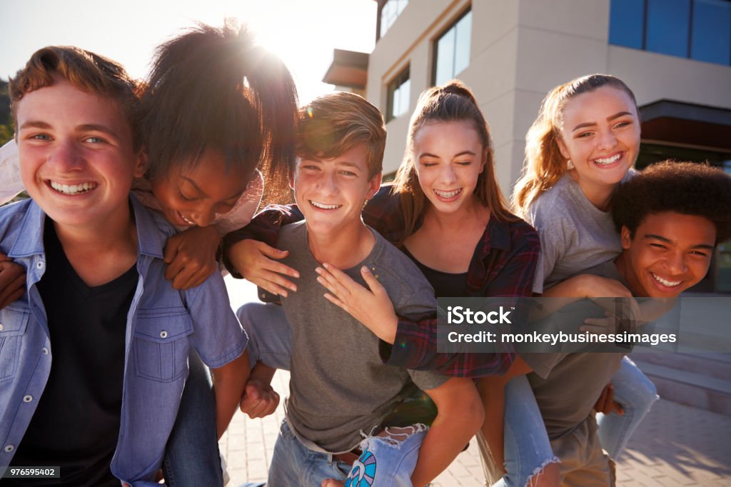 Retrato de estudantes do ensino médio dando uns aos outros edifícios do colégio sobreposto - Foto de stock de Adolescente royalty-free