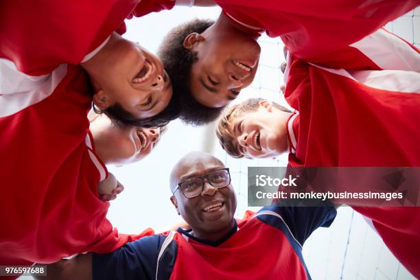 Low Angle View Of Male High School Soccer Players And Coach Having Team Talk Stock Photo - Download Image Now