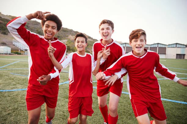 portret męskiej drużyny piłkarskiej szkoły średniej świętuje - football child american football team zdjęcia i obrazy z banku zdjęć