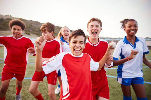 portret męskich i żeńskich drużyn piłkarskich szkół średnich świętuje - football child american football team zdjęcia i obrazy z banku zdjęć