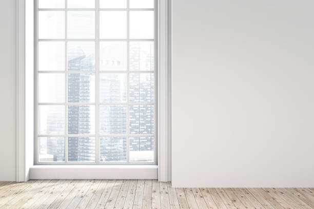 istock Empty white room with a window and cityscape 976598420