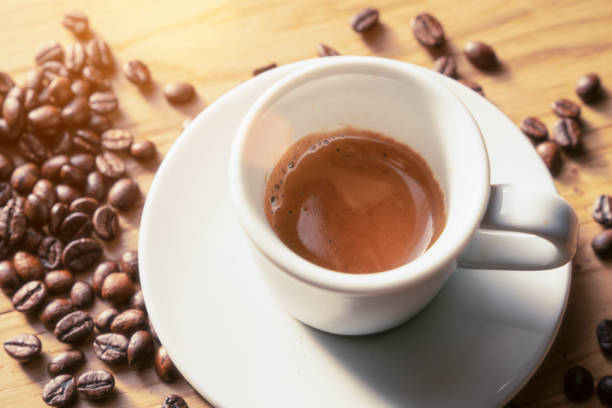 istock Cup of Espresso (shot) on wooden table decorated with coffee beans 976604056