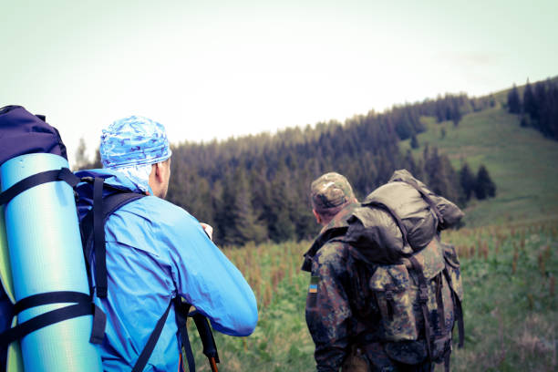 istock Photographer with camera on tripod shooting a landscape in forest 976611322