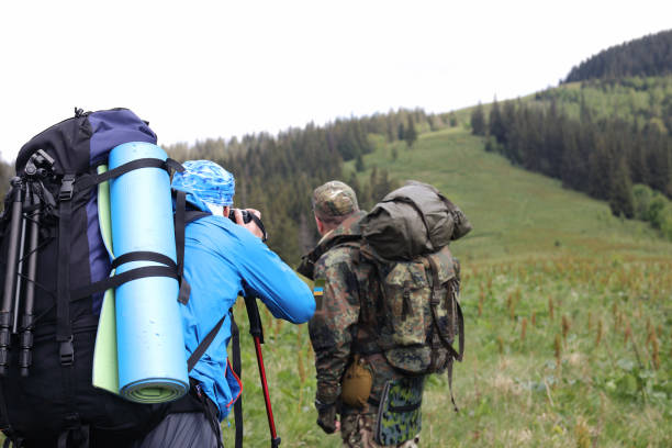 istock Photographer with camera on tripod shooting a landscape in forest 976611420