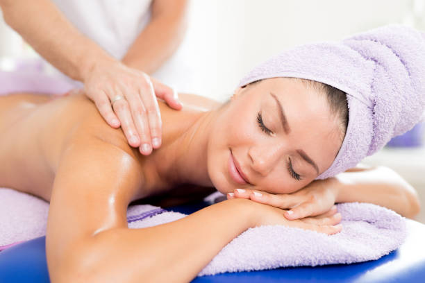 Peaceful brunette enjoying an exfoliating back massage in the health spa