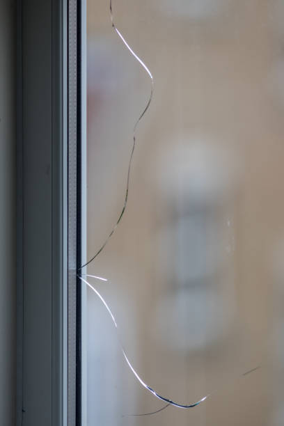 istock Cracked window. Broken glass pane in double-glazing. 976619124