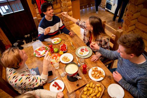 istock Coworkers Eating Dinner in a Log Cabin 976629140