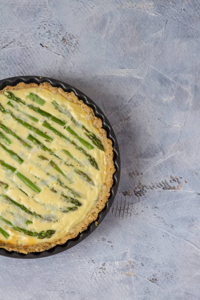istock Green asparagus tart with goat cheese. Gray table. Isolated. 976629606