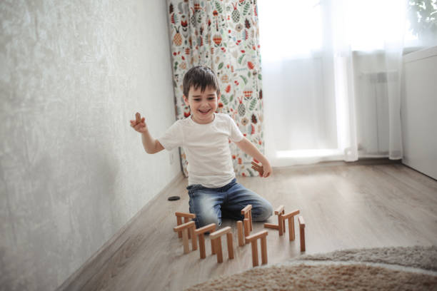 少年白人ブルネット床で幸せな演奏 - block child play toy ストックフォトと画像