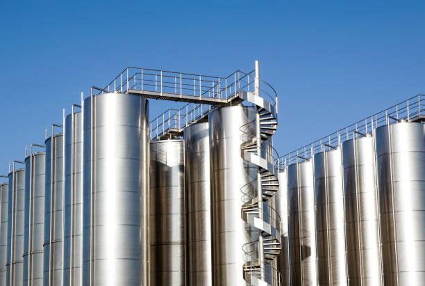 istock Silver wine Silos with blue sky in background 976632998