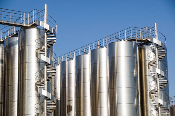 istock Silver wine Silos with blue sky in background 976633220