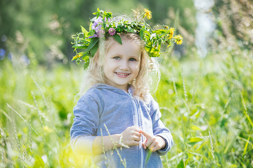 Little beautiful baby girl outdoors in a field in the fresh air happy