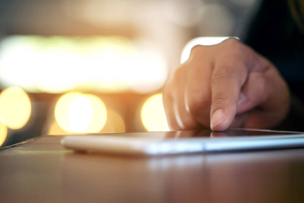 istock A woman's hand touching and using a smart phone with blur bokeh background 976638100