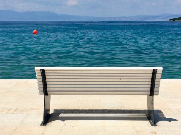 istock Bench by the sea in sunlight 976644860