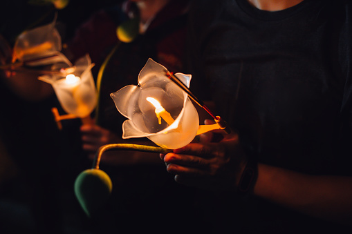 Budistas orando con incienso sticks, flor de loto y velas en el día de la Santa religión de Vesak en la noche photo