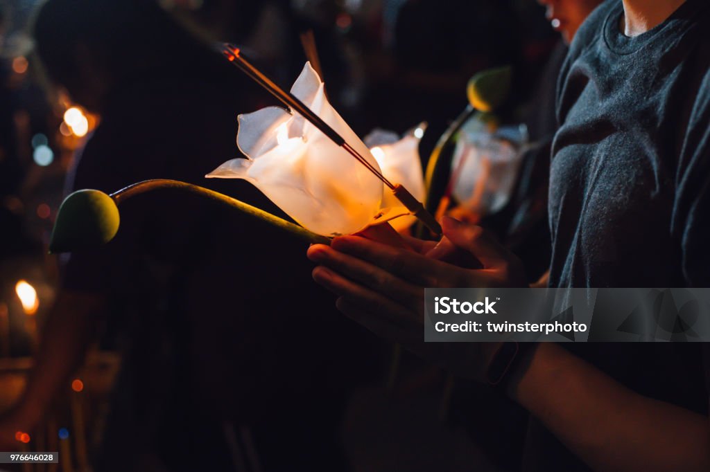 Buddhist praying with incense sticks, lotus flower and candles on holy religion day of Vesak at night Vesak Day Stock Photo