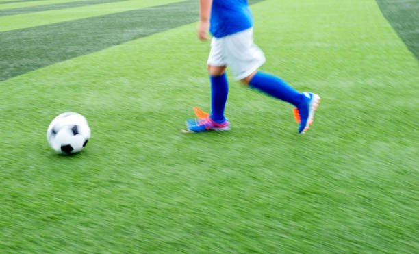 istock Young boy running after a soccer ball 976656850