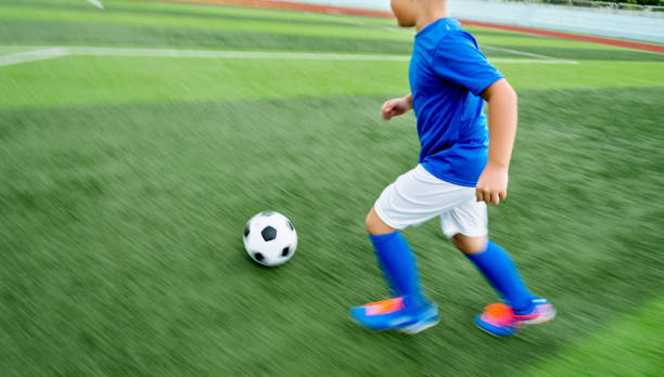 istock Young boy running after a soccer ball 976656858