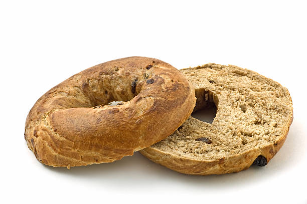 A plain bagel cut in half for breakfast Fresh baked cinnamon and raisin bagel isolated on white background in horizontal format Cinnamon Raisin Bagel stock pictures, royalty-free photos & images