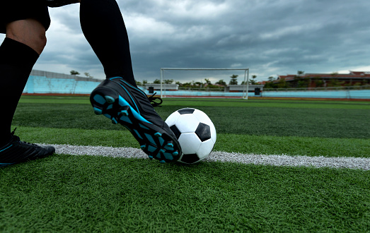 Soccer player foot kicking soccer ball