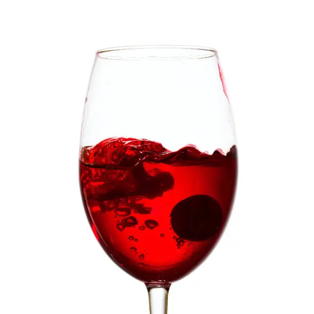 Photo of wine in a glass with a dark grapes