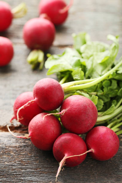 istock Red radishes on grey wooden table 976666718