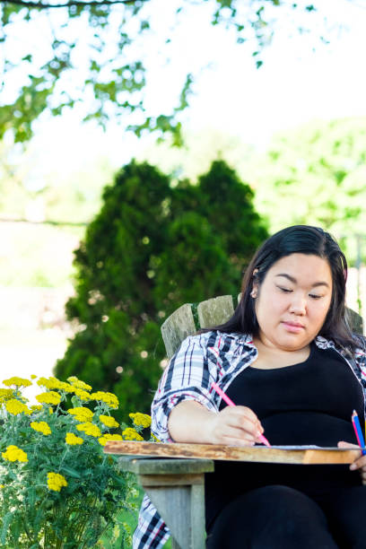 istock Young Woman Sitting Outside Coloring 976669368