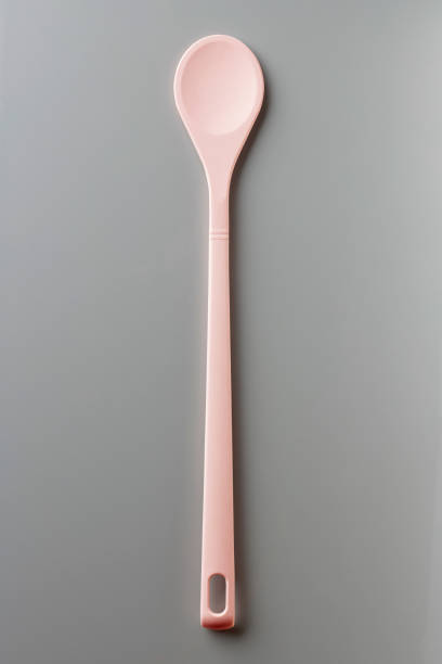 istock Pink silicone spoon on grey, from above 976679412