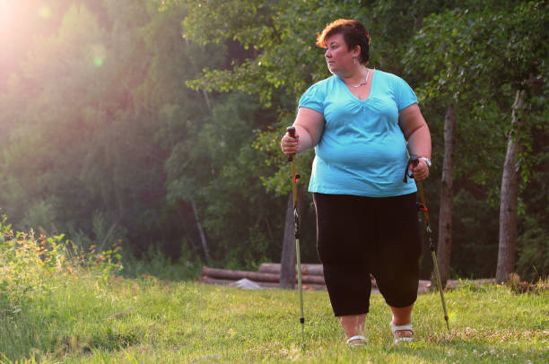 übergewichtige frau zu fuß auf waldweg. schlankheitskur und aktives lifestyle-thema. - running track women running spring stock-fotos und bilder