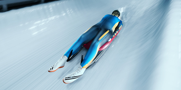 Female Luger glides on the sleigh in professional Luge Track on competition. Sportswoman dressed in a suit for sledge sports and protective helmet