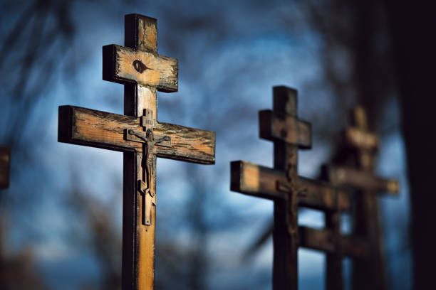 Old orthodox cemetery. Wooden crosses in sunlight against sky, shallow dof, close up