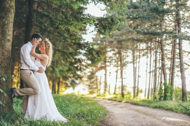 istock Happy newlyweds standing on road through the forest 976741028