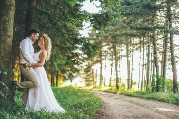 istock Happy newlyweds standing on road through the forest 976742920