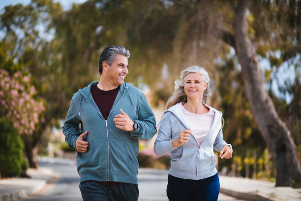 istock Happy multi-ethnic retired mature couple jogging together in spring 976748064