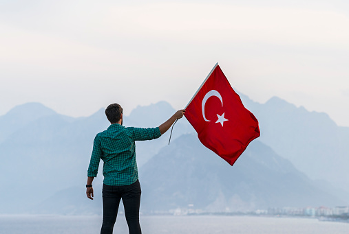 Young man flying Turkish flag, Antalya Turkey