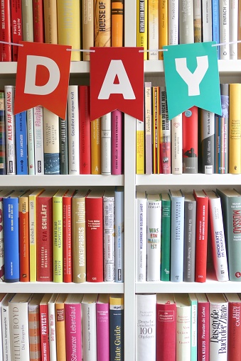 day letters hanging on bookshelf in library