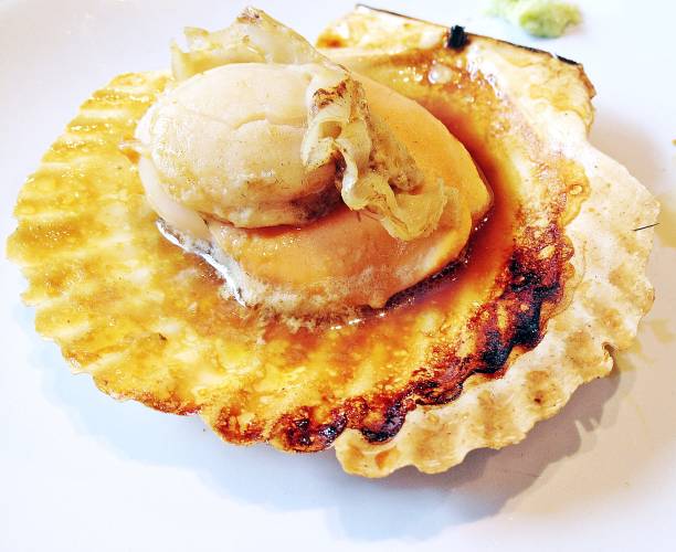 Grilled fresh scallop with soil sauce in hard shell