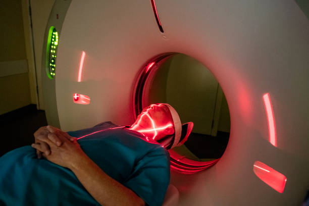 istock Red laser lines on patient's face in CAT scanner 976775740