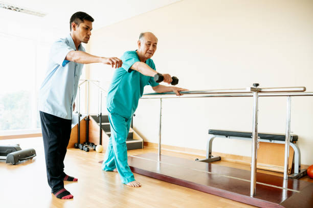 istock Senior man using hand weight in physiotherapy session 976776926