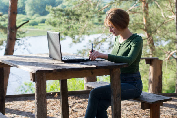 istock Beautiful young girl using her graphic tablet outdoors 976781376