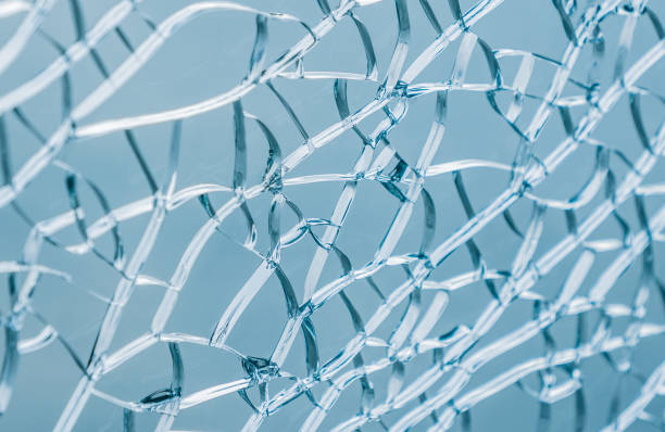 istock Middle focus picture of broken glass cracks on blue background 976797080