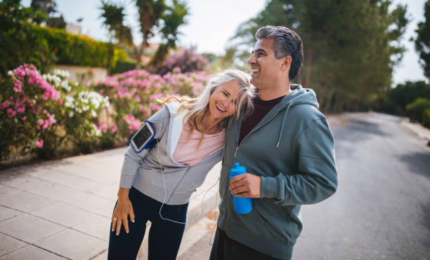 couple de personnes âgées multiethnique active s’amuser après jogging en plein air d’entraînement - headphones relaxation outdoors caucasian photos et images de collection