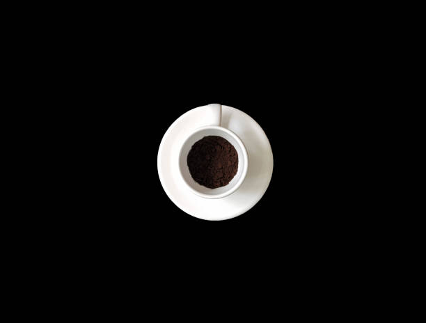 istock White coffee cup with coffee powder on black background,white cup on white saucer. 976806970