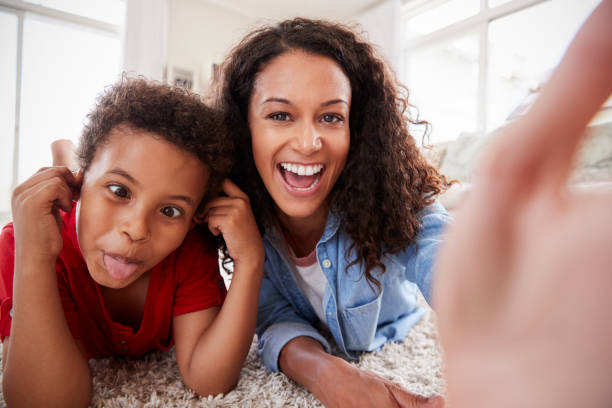istock Mother And Son Lying On Rug And Posing For Selfie At Home 976807942